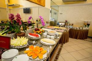 a buffet with plates of food on a table at Hotel Golden Park Campinas Viracopos By Nacional Inn in Campinas