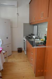 a kitchen with wooden cabinets and a sink and a refrigerator at Apartment Enny in Blagaj
