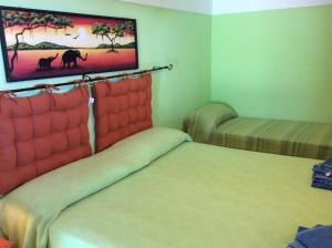 a room with two beds and a painting on the wall at Venus Dream in Pantelleria