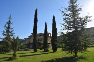 una casa con un gruppo di alberi nell'erba di Villa Cristina a Pontelatone