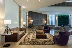 a living room with a couch and chairs and a table at K Hotel in Goiânia