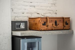 a suitcase sitting on a shelf next to a tv at The Boutique Napoli Suite in Naples
