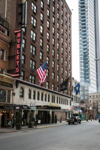 un gran edificio con banderas americanas en una calle de la ciudad en The Gallivant Times Square en Nueva York