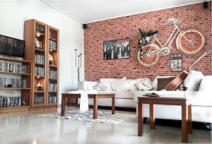 een woonkamer met een witte bank en een bakstenen muur bij Saki's apartment in Athene