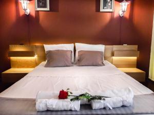 a bedroom with a bed with towels and flowers on it at Saki's apartment in Athens