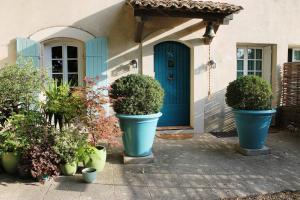 a house with three large blue pots with plants at Le Mas Turquoise, B&B Spa-Color Inclus in Bédarrides