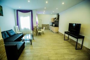 - un salon avec un canapé et un piano dans l'établissement Apartamentos Bcntourism, à Pineda de Mar