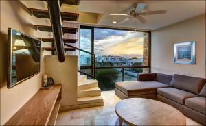 sala de estar con sofá y ventilador de techo en Anah Suites by Las Flores, en Playa del Carmen