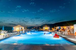 a pool with people in it at night at Luštica Apartments in Luštica