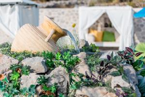 a garden with a hammer on a pile of rocks at Luštica Apartments in Lustica