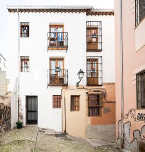 ein weißes Gebäude mit Fenstern und Balkonen in der Unterkunft Livings en Elvira Centro in Granada