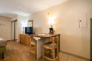 a room with a desk with a bed and a television at Studio 6 Extended Stay - Duluth, GA - Atlanta - Gwinnett Place in Duluth