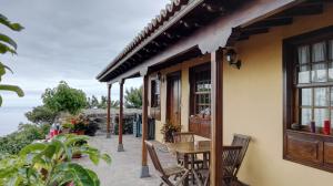 dom ze stołem i krzesłami na patio w obiekcie Casa Los Quemados w mieście Fuencaliente de la Palma