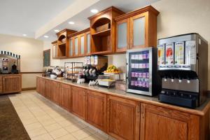 a restaurant with a counter with a drink refrigerator at Country Inn & Suites by Radisson, Ithaca, NY in Ithaca