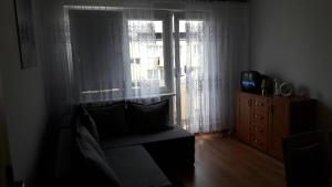 sala de estar con sofá y ventana en Śpiew Mew, en Ustka