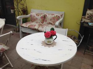 Una mesa blanca con un jarrón con flores. en Hostal Renoir, en San Fernando