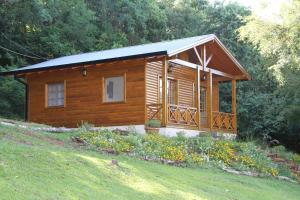 a small wooden cabin in a field of grass at La Linda Cabañas in Dos de Mayo