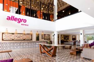 a lobby of a hotel with a table and chairs at Allegro Cozumel All-Inclusive in Cozumel