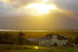 a house on a hill with the sunset in the background at Kilburn House B&B in Milltown