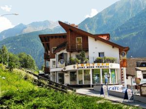 a building on a hill with mountains in the background at Pepis Ferienwohnungen inklusive Sommercard in Jerzens