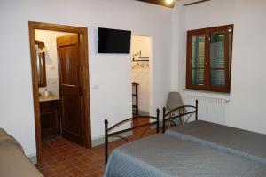 聖塞波爾克羅的住宿－La Collina di Piero，卧室配有一张床,墙上配有电视