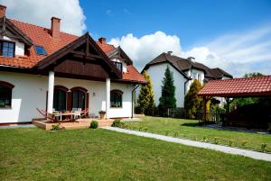 una casa con un patio de césped y un cenador en Willa Cicho Sza, en Węgorzewo