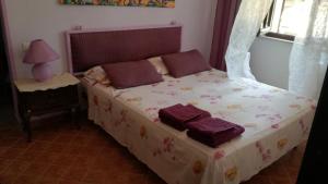 1 dormitorio con 1 cama con mantas moradas y ventana en Casa Marieva, en Pula