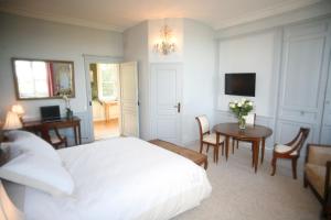 1 dormitorio con cama, mesa y TV en Chambres d'hotes Autour de la Rose, en Honfleur