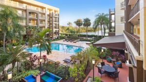 an aerial view of the pool at a resort with palm trees at Best Western Plus Deerfield Beach Hotel & Suites in Deerfield Beach