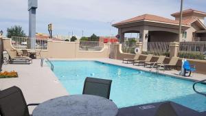 a large swimming pool with chairs and a table at Best Western El Rancho Palacio in Roswell