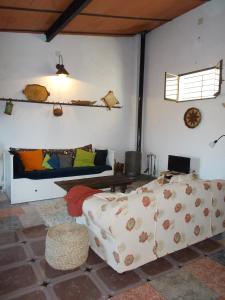 a living room with a couch and a bed at La Tierra Verde Casita in Alcuéscar