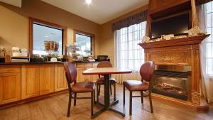 a kitchen with a table and chairs and a fireplace at Best Western Pontiac Inn in Pontiac