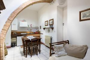 a living room with a table and a kitchen at Antiche Dimore Vescovado in Murlo