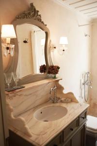 La salle de bains est pourvue d'un lavabo et d'un miroir. dans l'établissement Amaryllis Boutique Guest House, à Áno Pediná