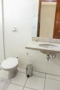 a white bathroom with a toilet and a sink at Hotel São Miguel in Sorriso +32 photos
