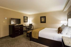 a hotel room with a bed and a desk at Best Western PLUS The Arden Park Hotel in Stratford