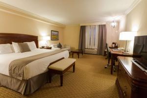 a hotel room with a large bed and a desk at Best Western PLUS The Arden Park Hotel in Stratford