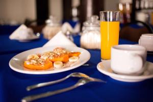 une assiette de nourriture sur une table avec un verre de jus d'orange dans l'établissement Hotel Go Inn, à Monclova