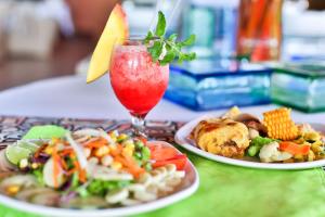a table with two plates of food and a drink at Best Western Jaco Beach All Inclusive Resort in Jacó