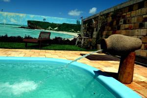 a hot tub with a water hose attached to it at Recanto do Rei Chalés in São Miguel do Gostoso