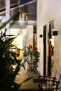 a patio with chairs and a table with flowers at Casa María Aeropuerto B&B in Alajuela
