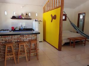 eine Küche mit Theke und Stühlen und einem Kühlschrank in der Unterkunft A Casa Azul in Barra Grande