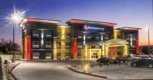 Best Western Plus Lampasas Inn & Suites في Lampasas: مبنى الفندق مع وجود سيارات تقف في موقف للسيارات