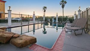 a pool with a bench and a picnic table next to a fence at Best Western Dayton Inn & Suites in Dayton