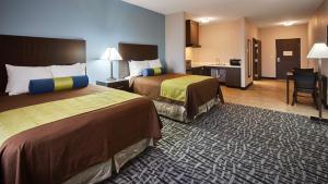 a hotel room with two beds and a kitchen at Best Western Plus Lonestar Inn & Suites in Colorado City