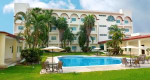 un complejo con piscina, sillas y un edificio en Best Western Plus Tuxtepec, en San Juan Bautista Tuxtepec