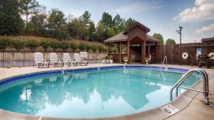 a large swimming pool with a gazebo at SureStay Plus Hotel by Best Western Poteau in Poteau