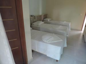 a room with three beds in a room at Areia do Atlantico Hotel in Porto Seguro