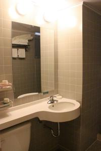 ein Badezimmer mit einem Waschbecken, einem Spiegel und einem WC in der Unterkunft Jinjiang Inn Longyan Wanda Plaza in Longyan