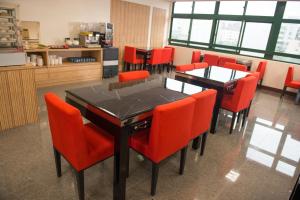 uma sala de jantar com cadeiras laranja e uma mesa preta em Ting-Shuai Motel em Jinshan